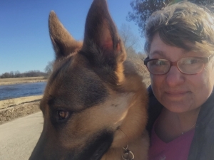 woman with short hair and german shepherd dog looking out of the picture